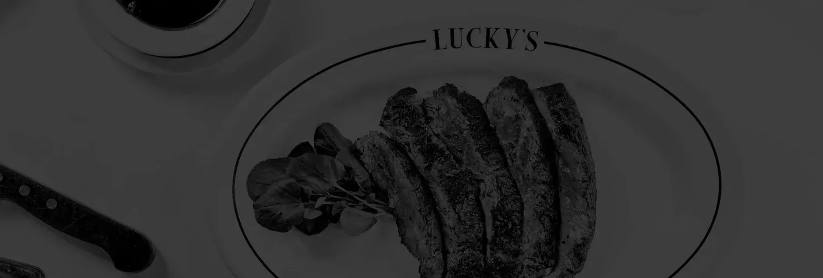 Contact Lucky's Steakhouse Beautifully plated Lucky's Steakhouse Romanian steak with classic sides
